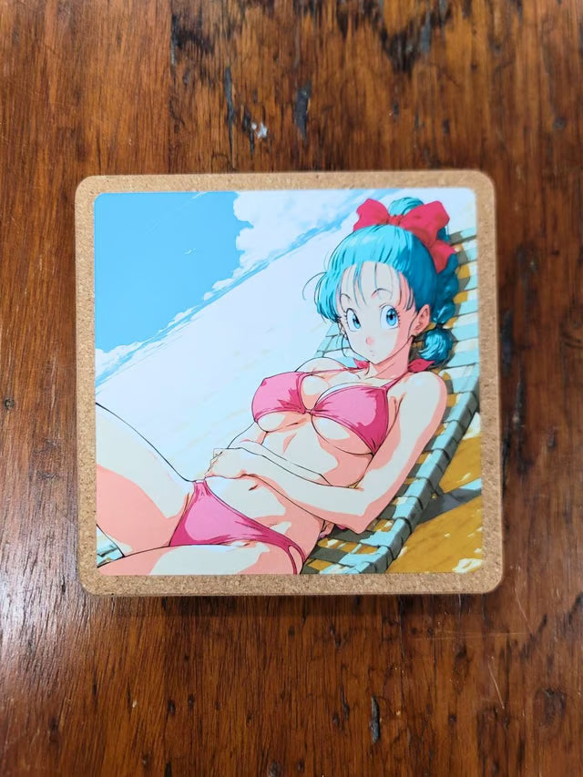 A square cork coaster featuring an anime illustration of Bulma from Dragon Ball Z lounging in a pink bikini on a beach, placed on a dark wooden table.