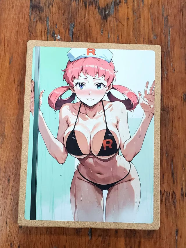 A rectangular printed item, likely a notebook, journal, or card, featuring an anime-style illustration of a pink-haired character in a black bikini with an 'R' on the cup and a nurse hat, placed on a wooden surface.