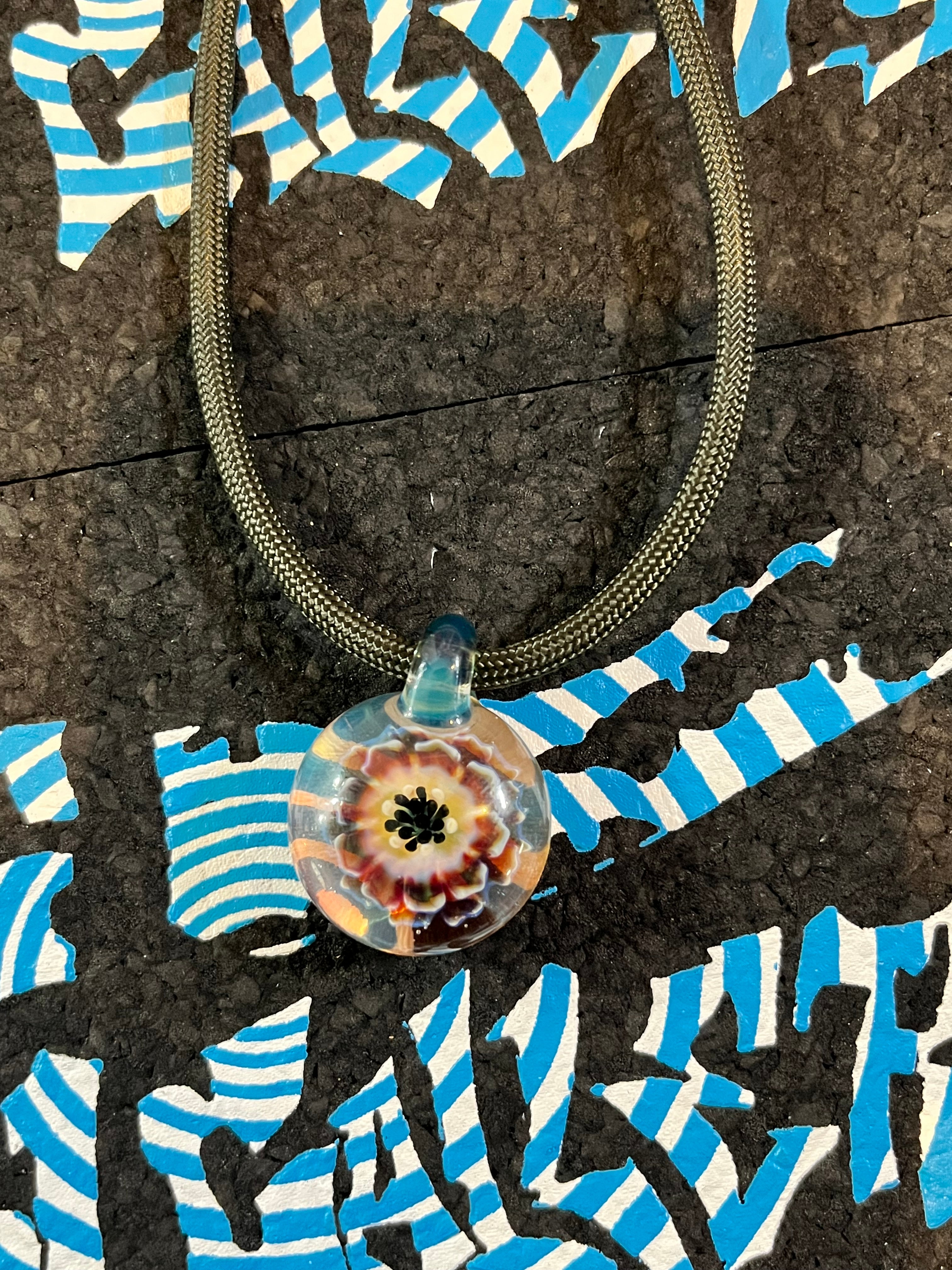 Roe Glass Flower Implosion pendant worn as jewelry, showcasing unique handcrafted design and elegant floral detail.